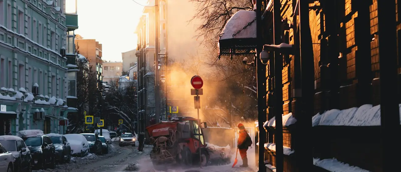 Verschneiter Gehweg entlang einer Grünfläche